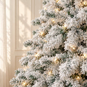 Détail du feuillage enneigé et des lumières chaudes du sapin blanc de 230 cm