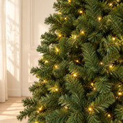 Détail du feuillage vert et des lumières chaudes du sapin de 230 cm