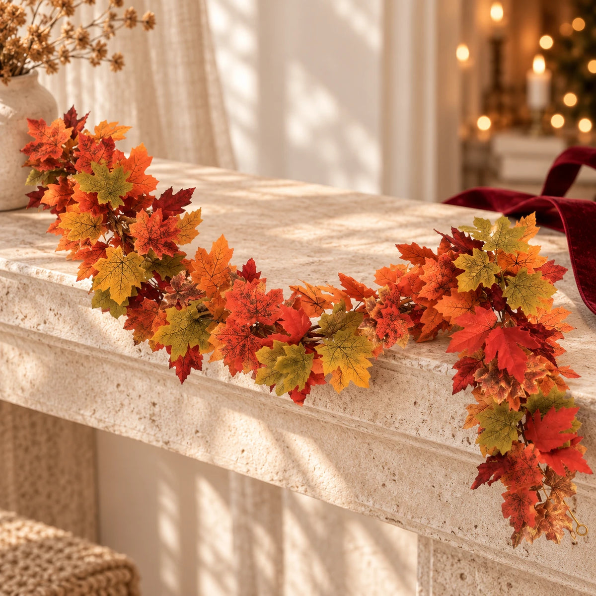 Guirlande artificielle de feuilles d’érable orange, rouge et olive sur une console claire