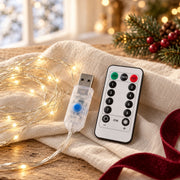 Télécommande blanche et connecteur USB transparent du rideau lumineux, sur une table en lin ivoire